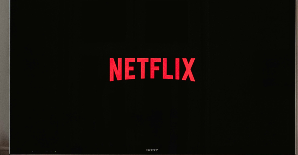 man lying on sofa infront of TV