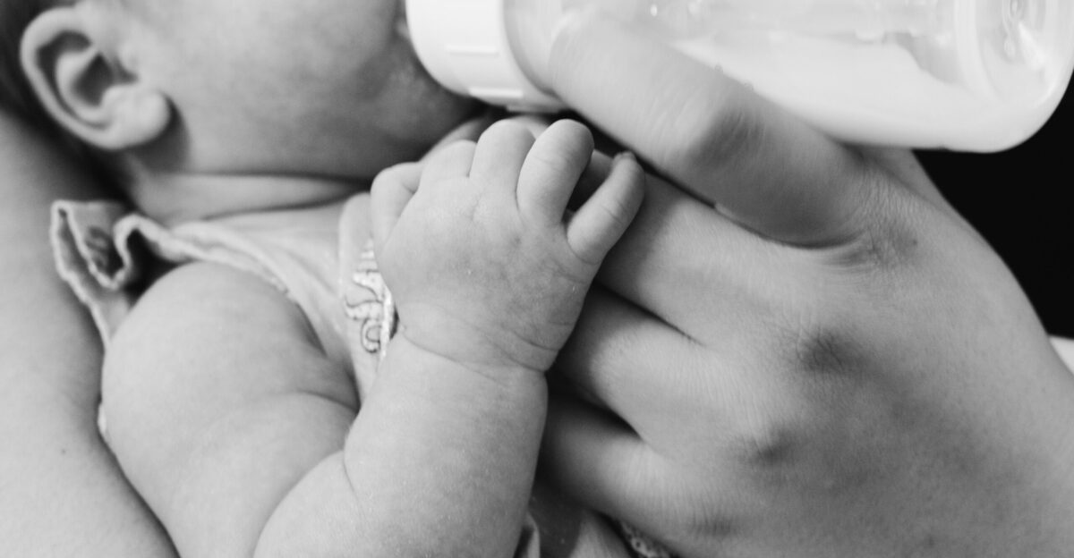 grayscale photo of baby feeding
