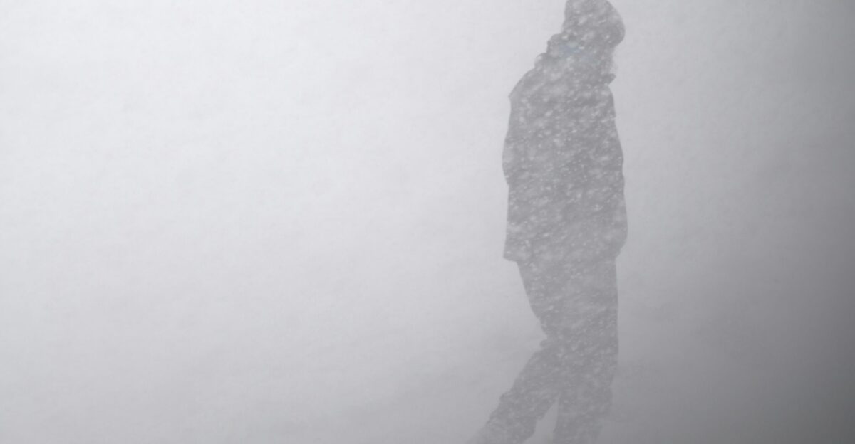 silhouette of man in snow storm