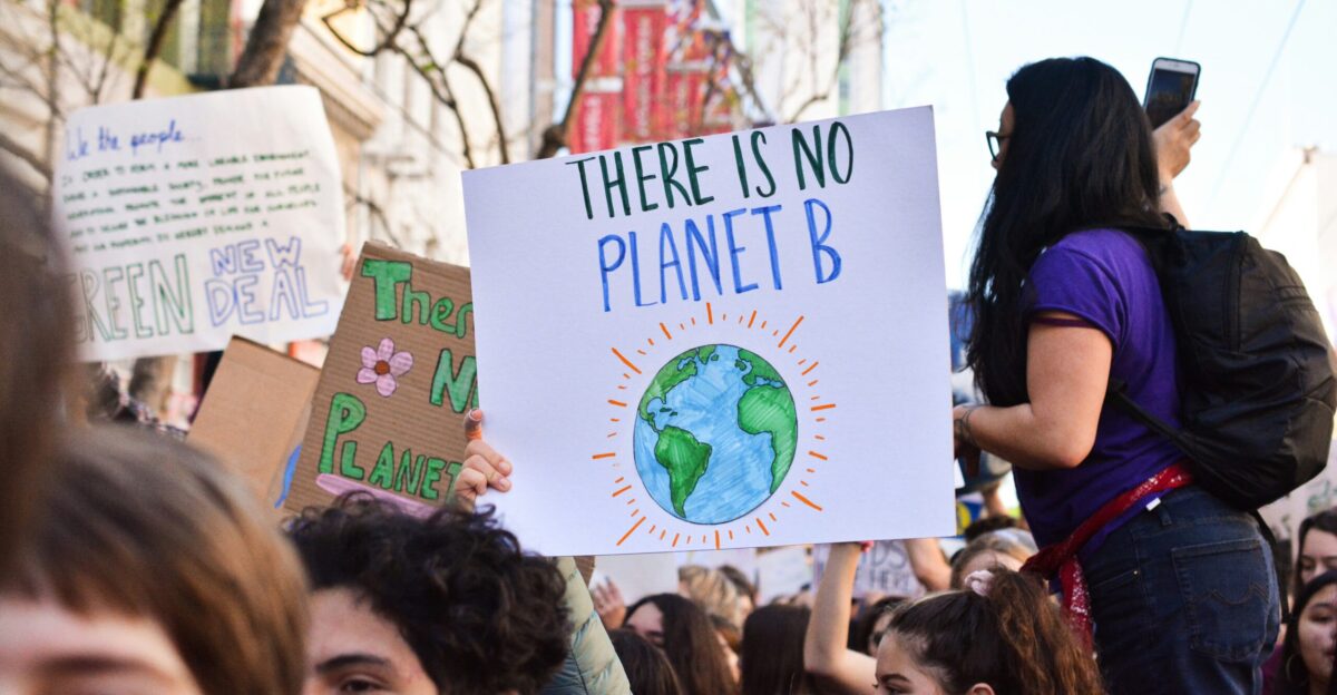person holding there is no planet b poster