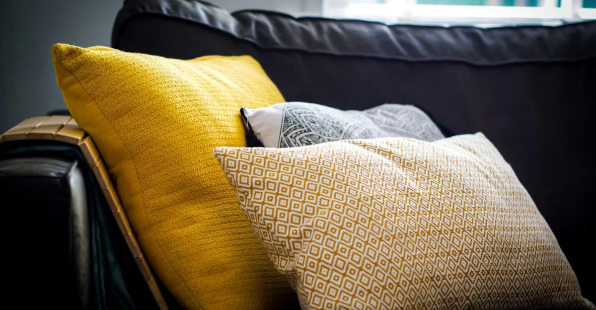 three assorted-color throw pillows on black sofa