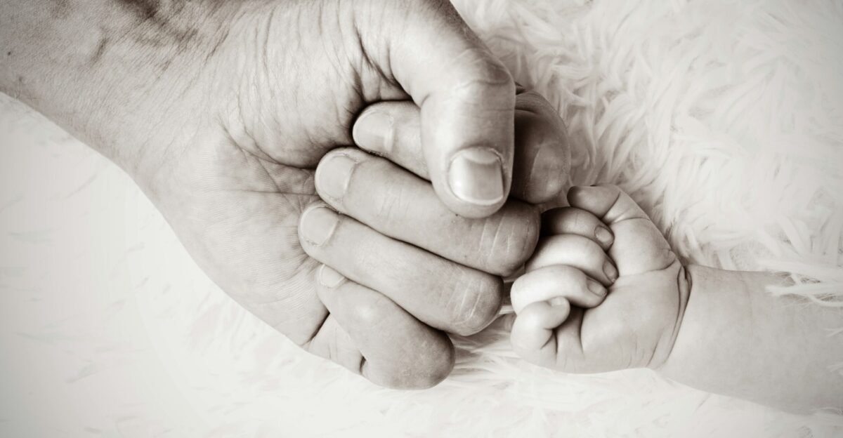 a close up of a person holding a baby s hand