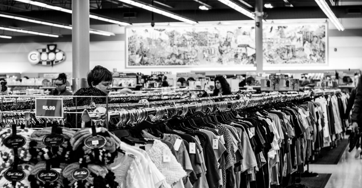 grayscale photography of people inside a clothing shop