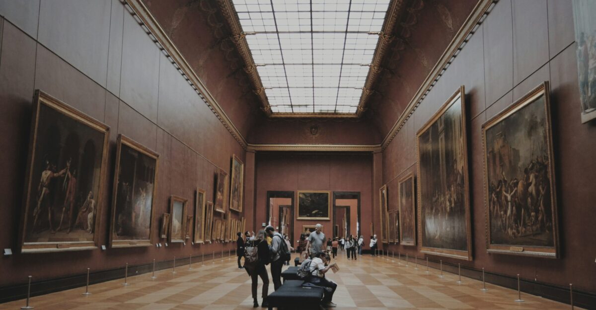 people walking on corridor looking at painting