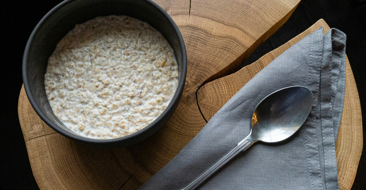 bowl of cereal beside spoon on wood slab