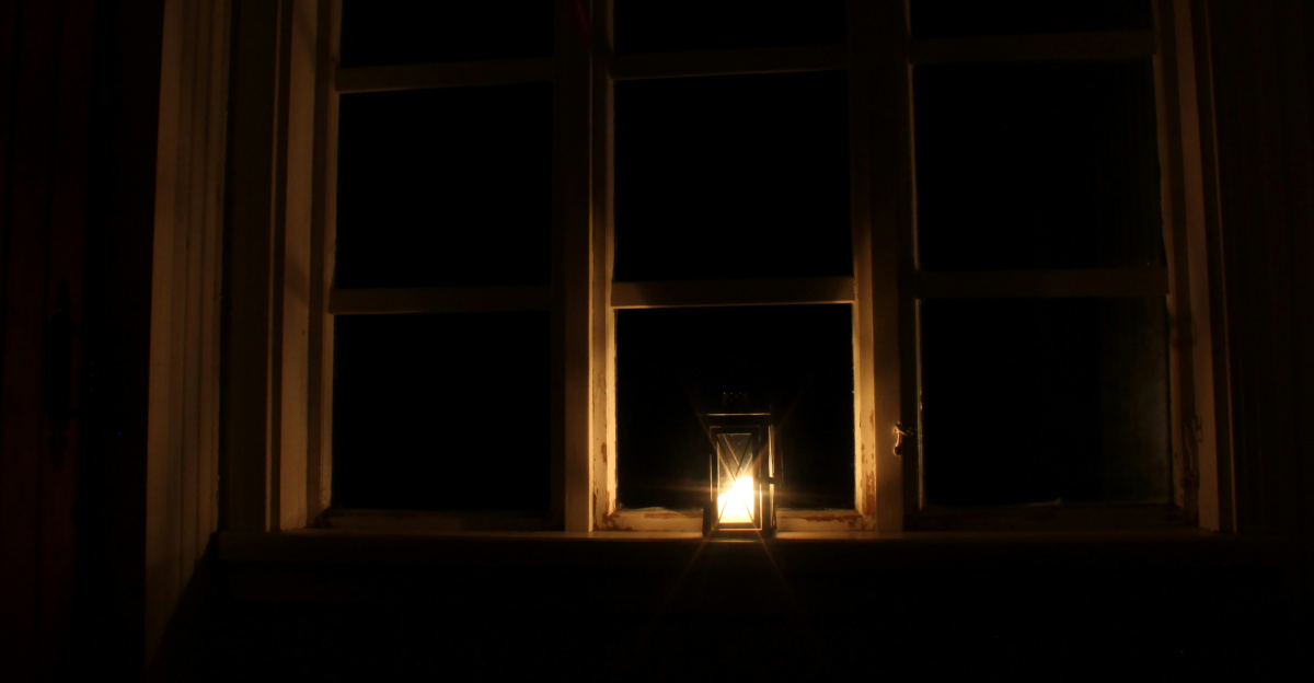 a candle is lit in front of a window