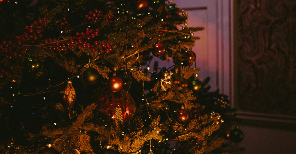 baubles and string lights filled Christmas tree by close door