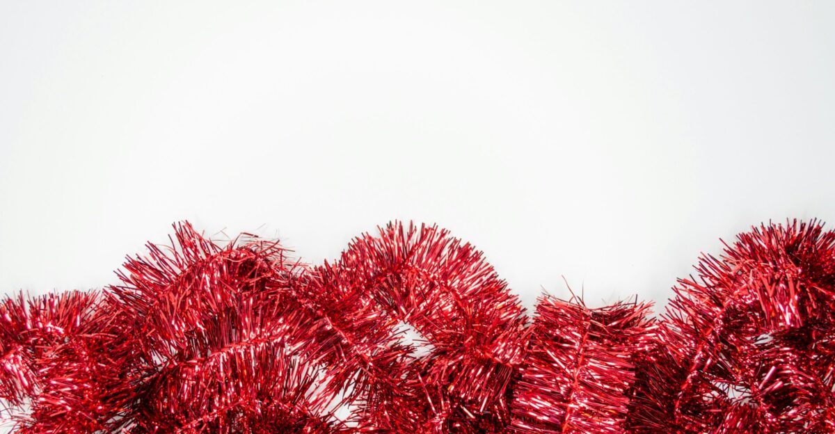 a bunch of red tinsel next to a white wall