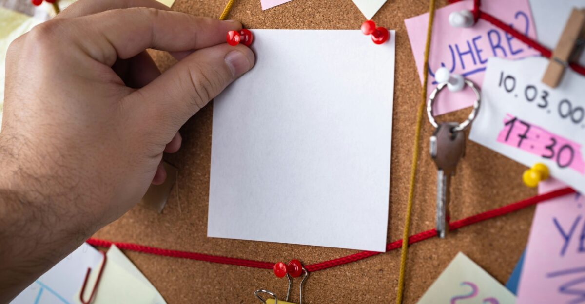 shallow focus photo of white paper sheet mounted on cork board