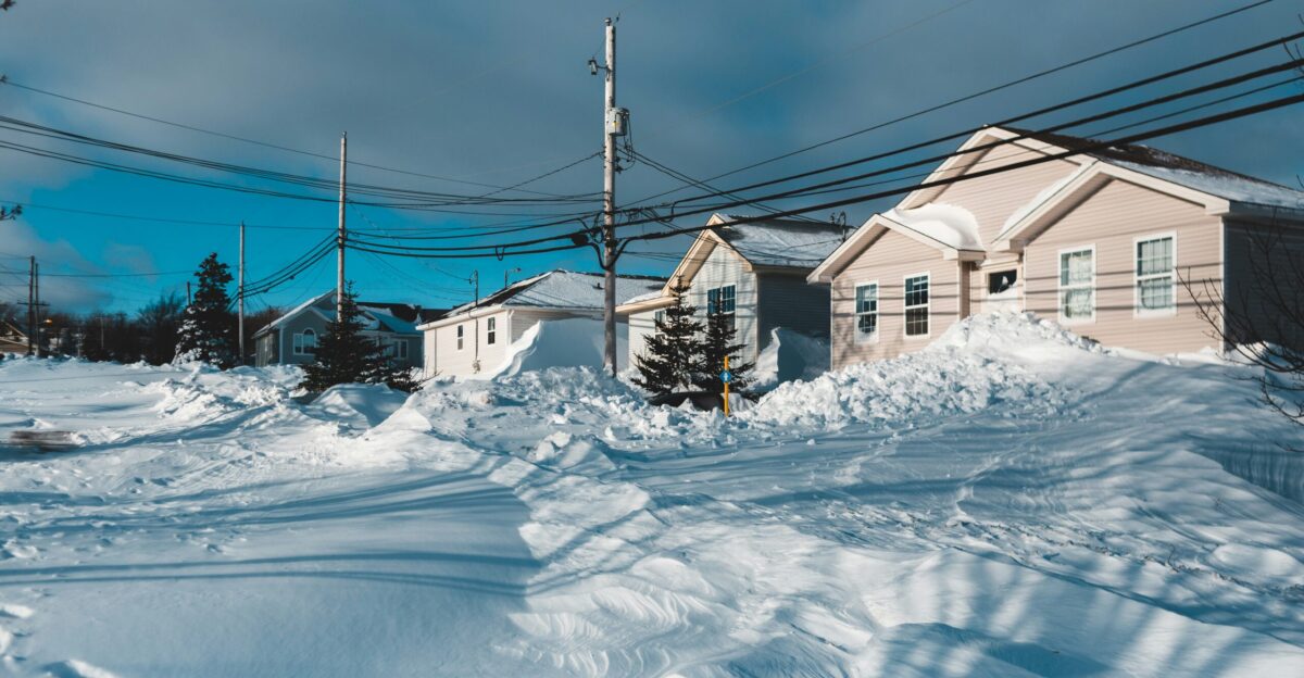 a snow covered street with houses and power lines
