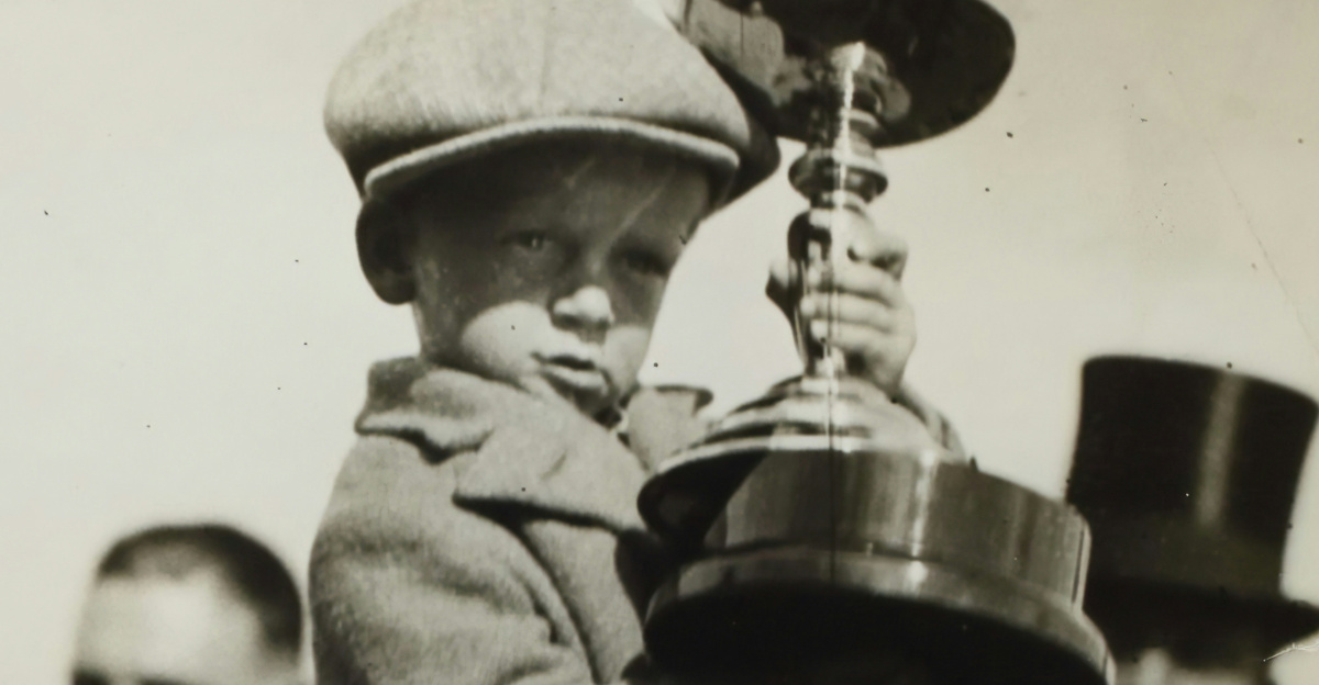man in black coat holding black metal candle holder
