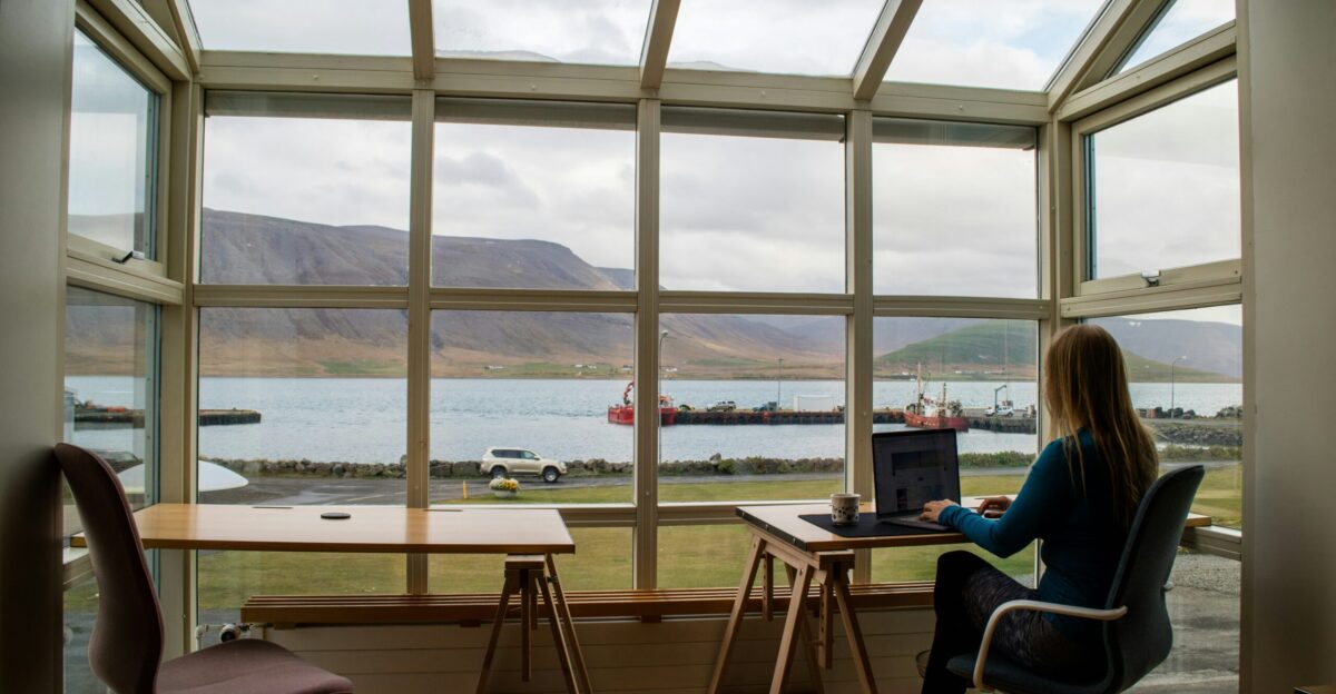 person in blue jacket sitting on brown wooden chair near brown wooden table during daytime
