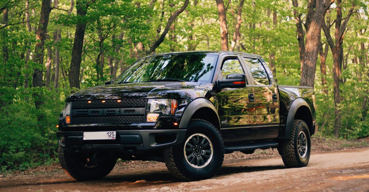 black and yellow chevrolet crew cab pickup truck parked on dirt road during daytime