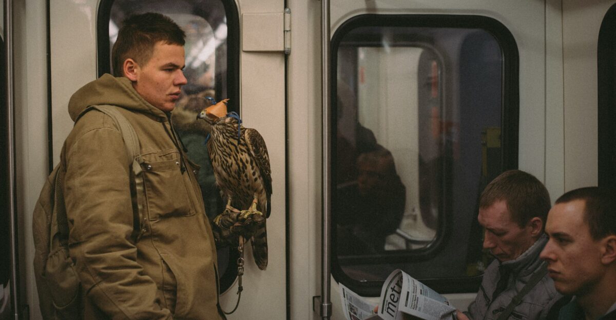 man in green jacket holding blue and white card