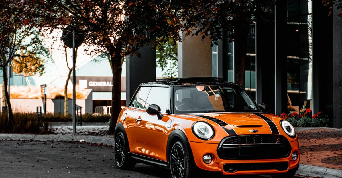 orange bmw m 3 parked on sidewalk during daytime