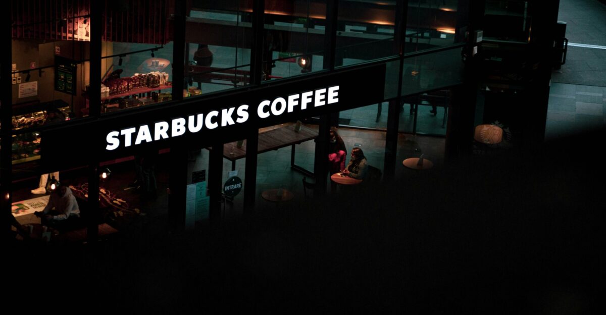 a starbucks sign hanging from the side of a building