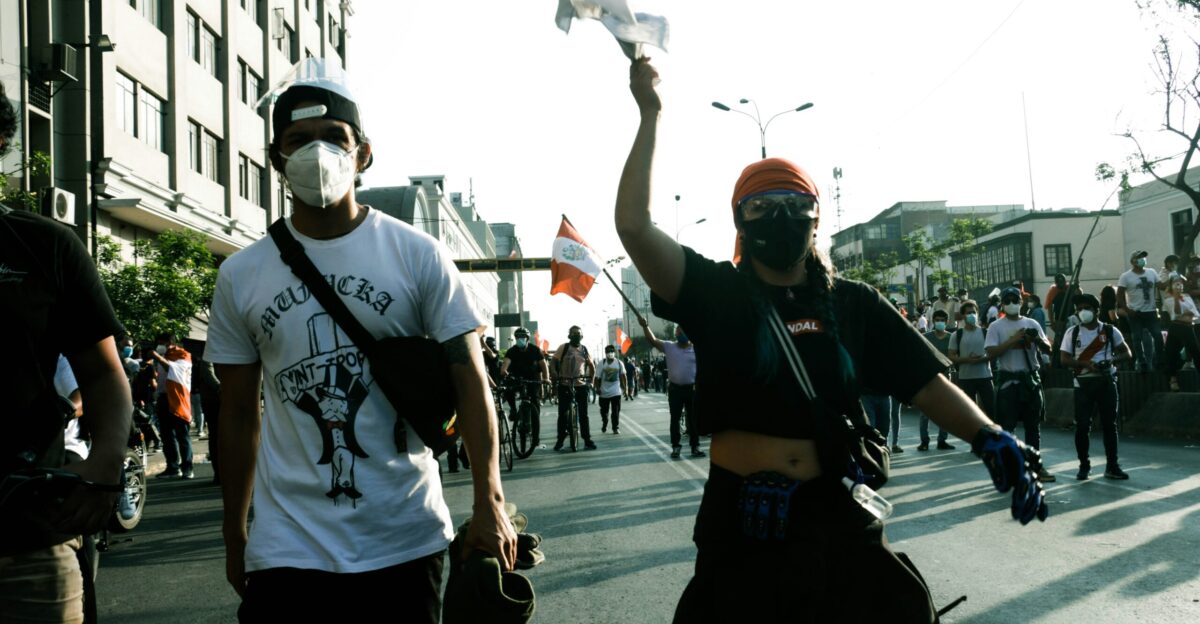 man in black and white crew neck t-shirt and black pants holding white plastic bag
