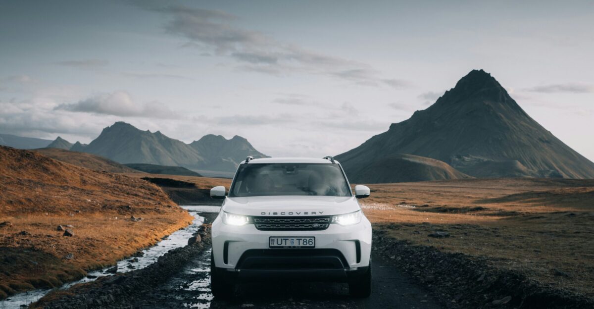 white nissan suv on brown field during daytime