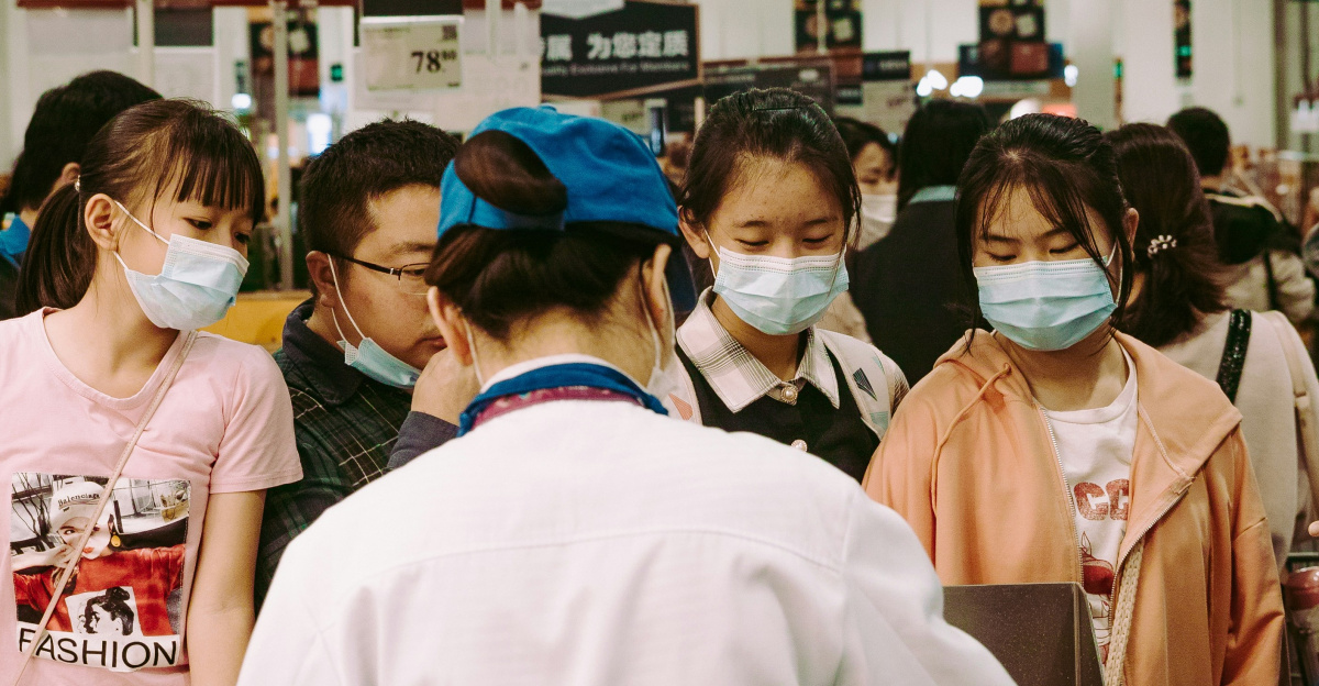 group of people standing in front of brown wooden table