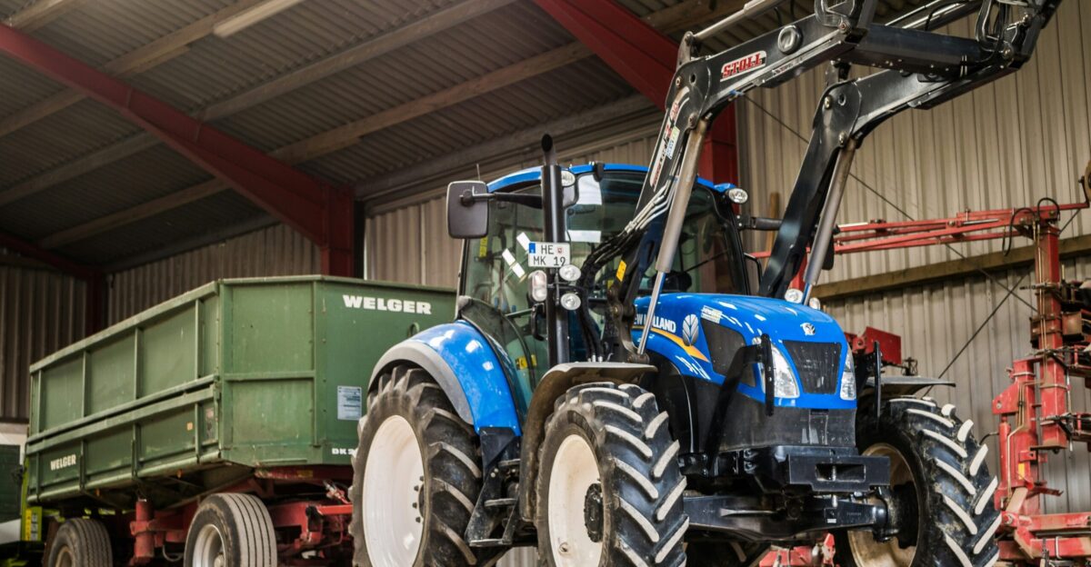blue and black tractor near green trailer
