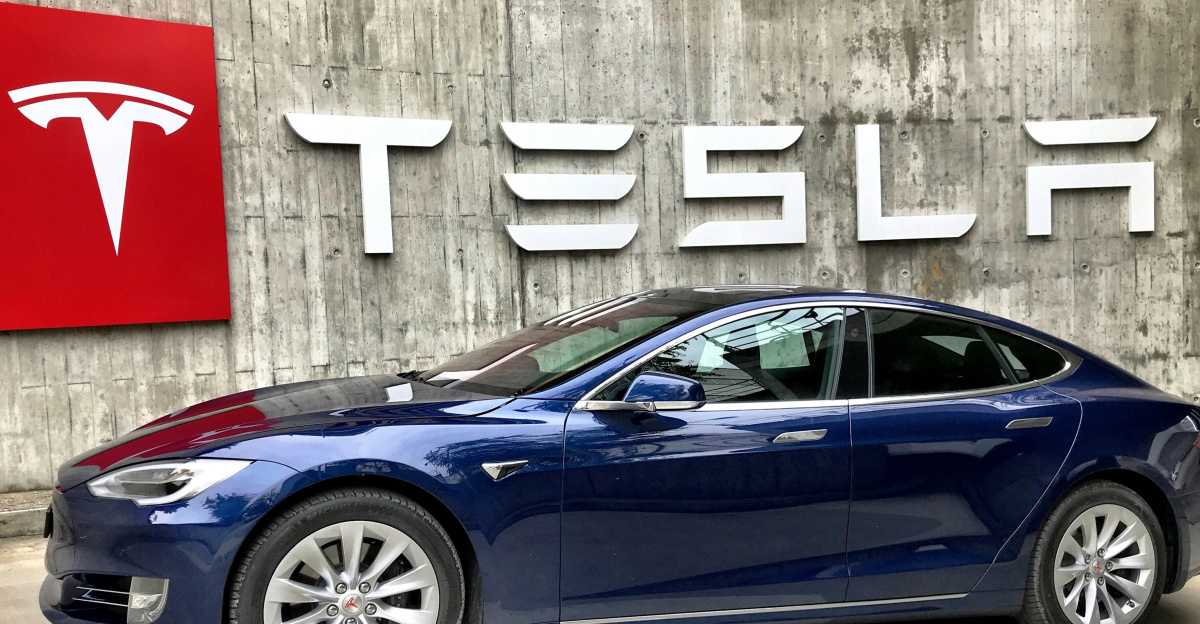 blue coupe parked beside white wall