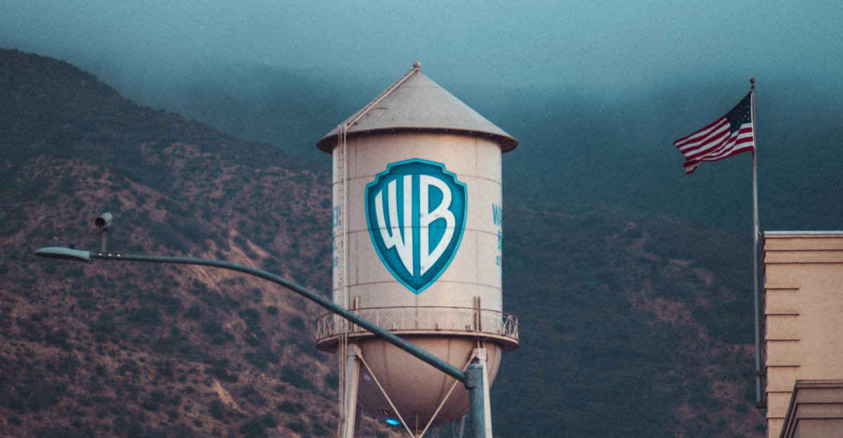 a water tower with a sign on it in front of a mountain