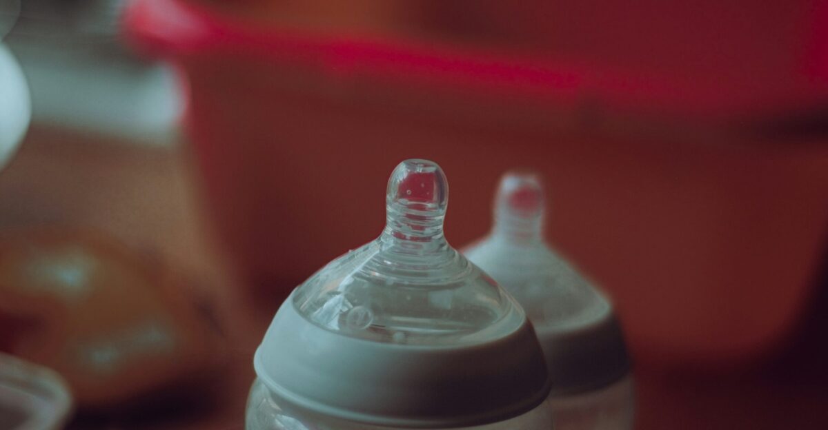 clear plastic feeding bottle on red table