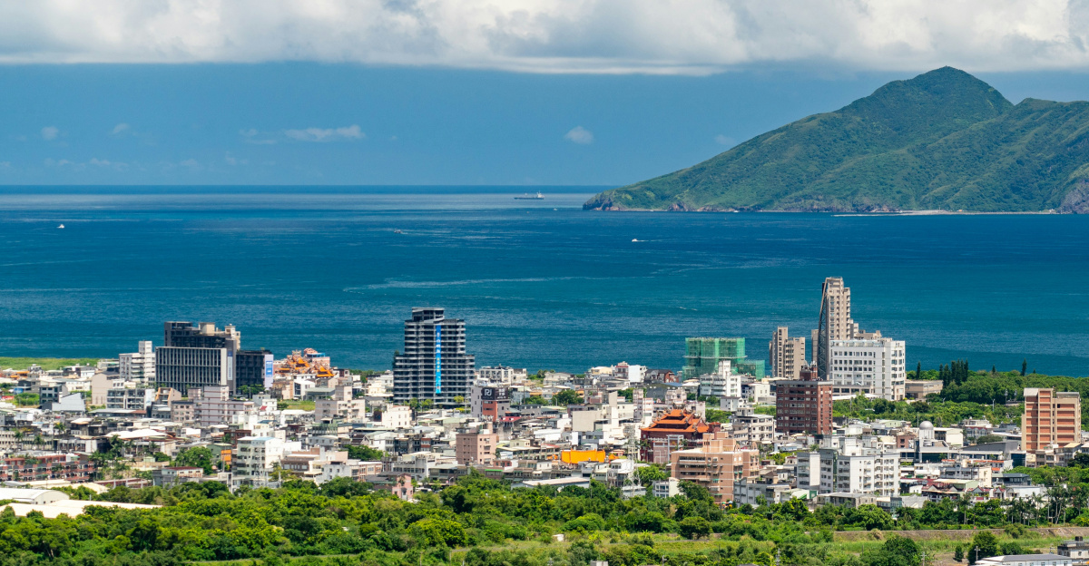 city near body of water under blue sky during daytime