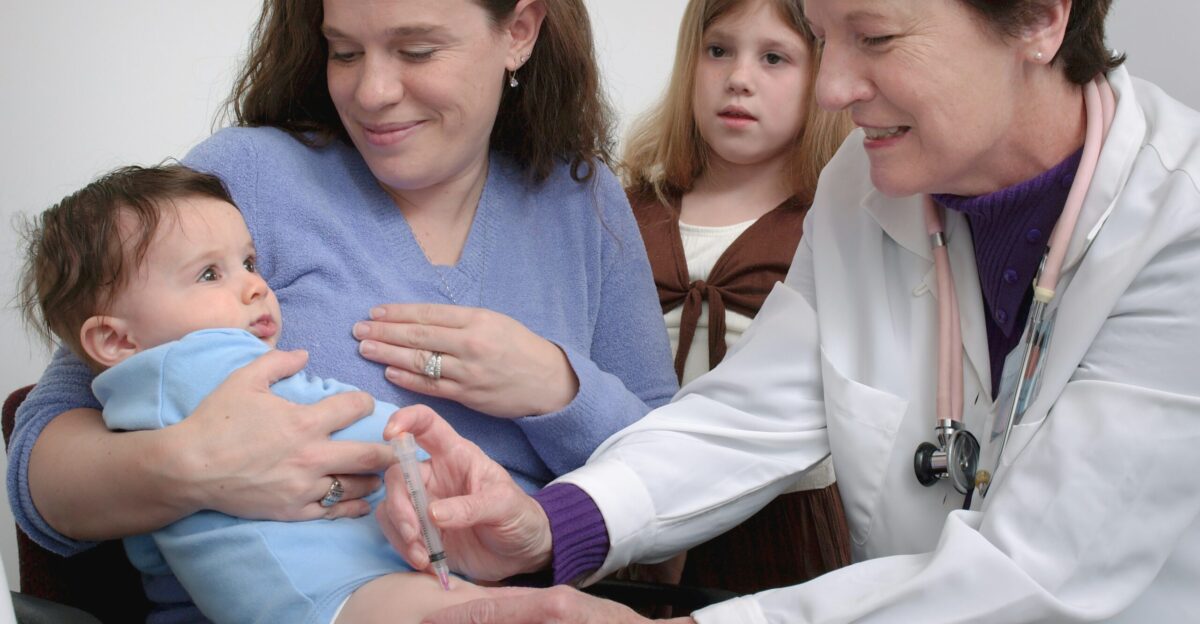 a woman in a white coat is holding a baby