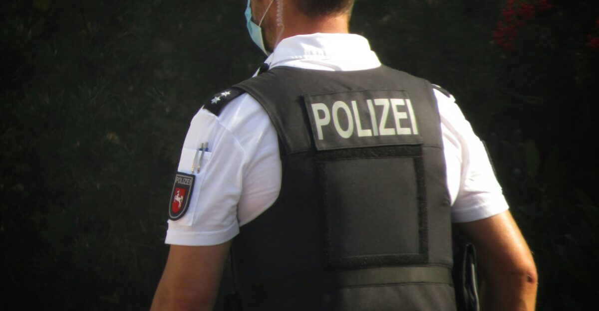 a police officer is standing in front of some trees