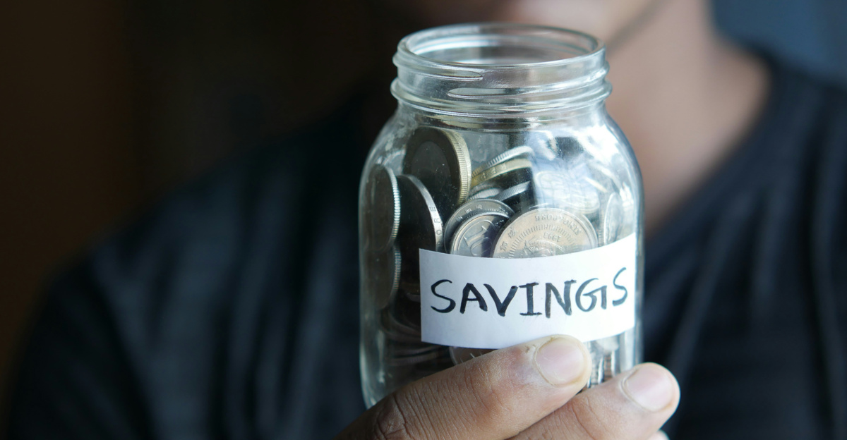 a man holding a jar with a savings label on it