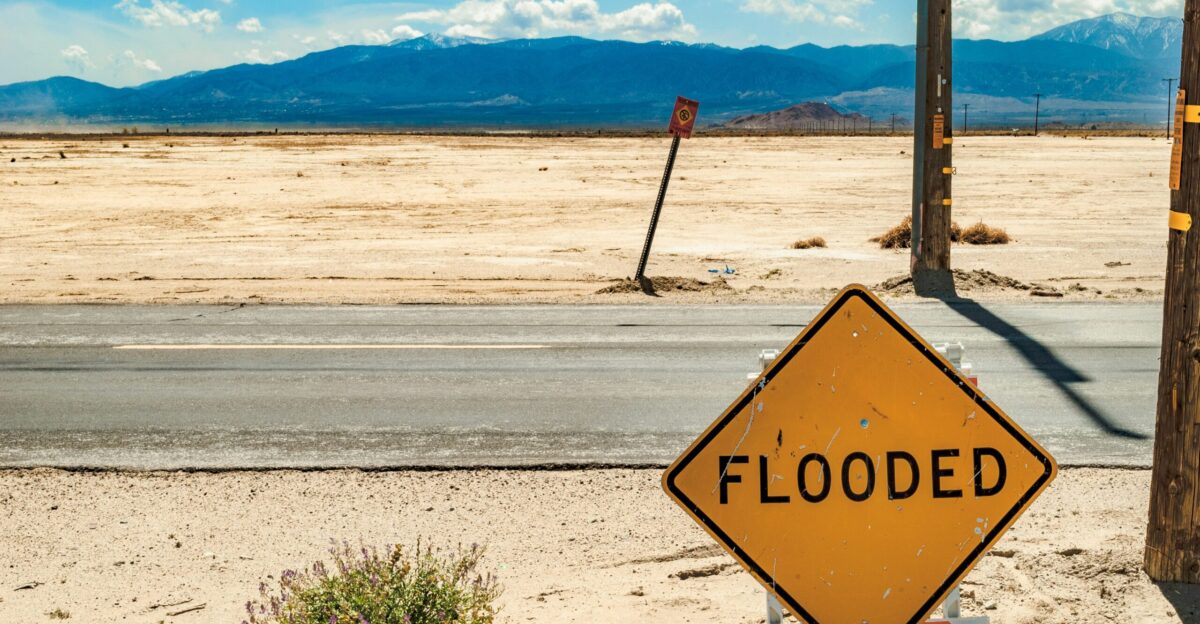 a yellow flood sign sitting on the side of a road