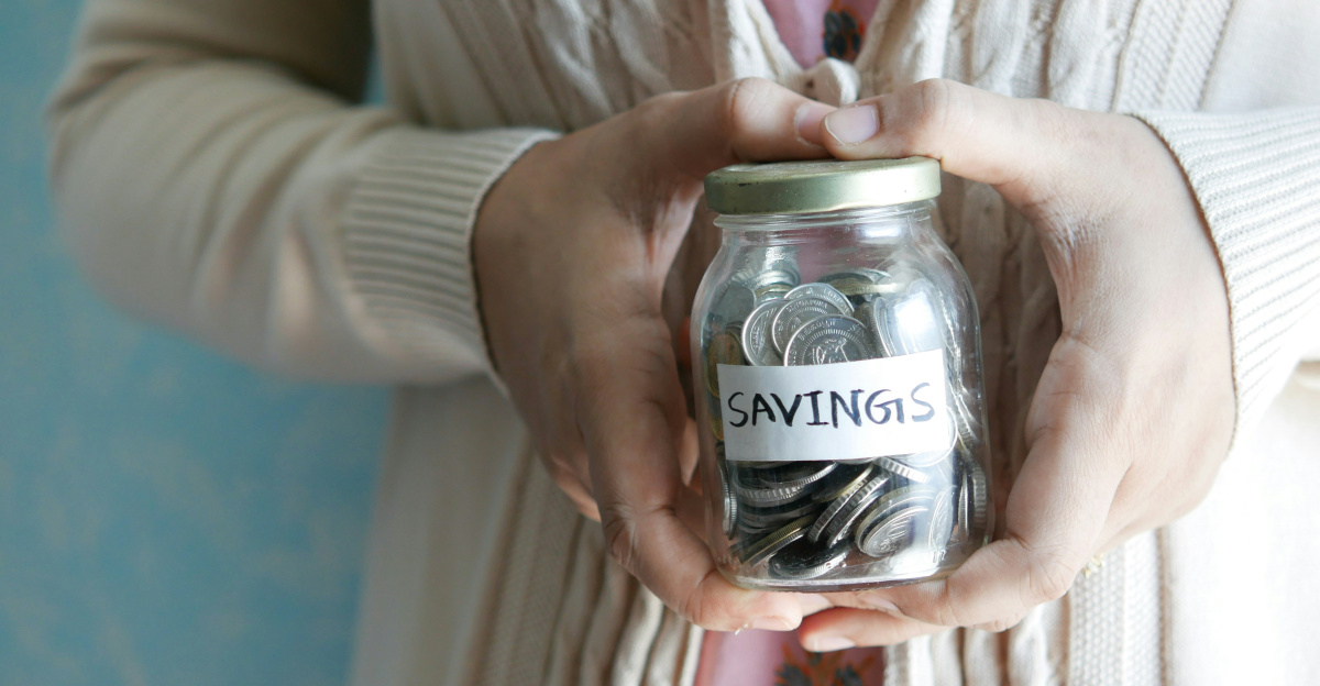 a woman holding a jar with savings written on it