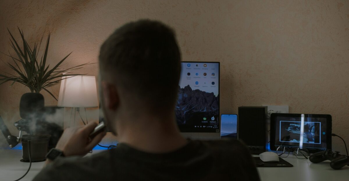 a man smoking a cigarette in front of a computer