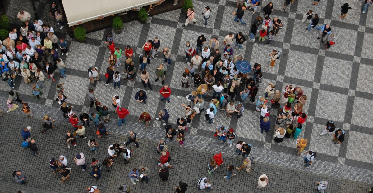 a group of people walking down a street next to each other