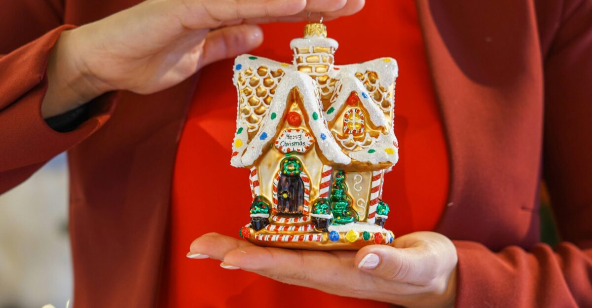 a woman holding a christmas ornament in her hands