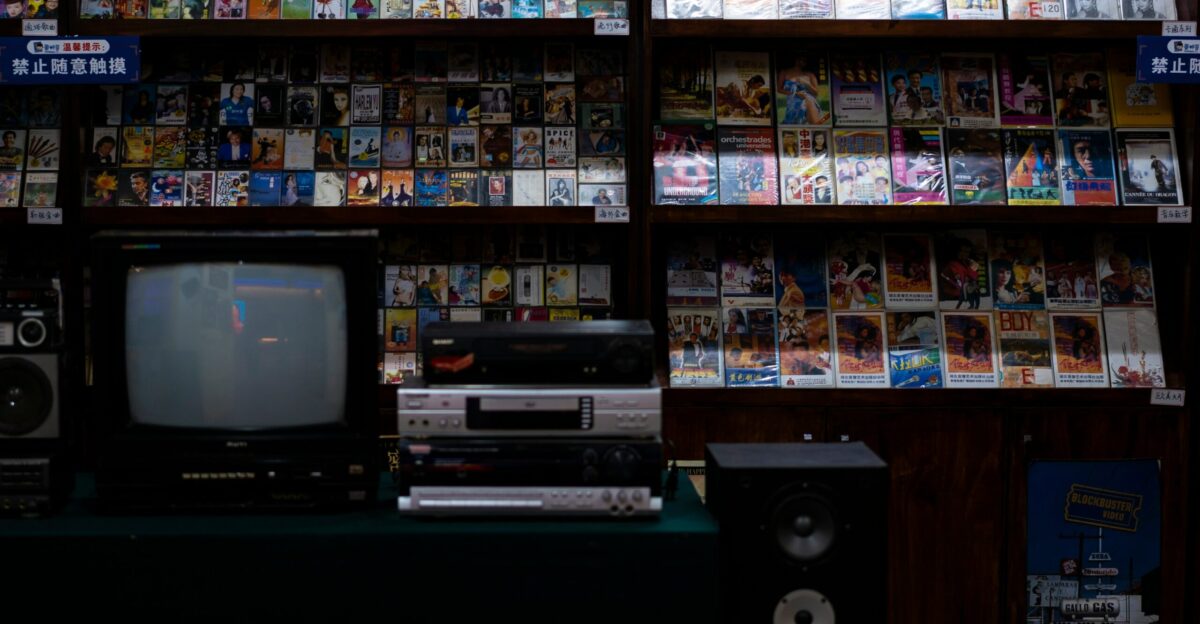 a television sitting on top of a table in front of a book shelf
