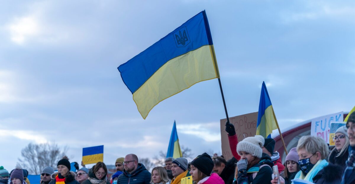 a crowd of people holding flags and signs