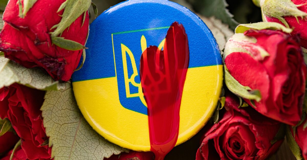 a blue and yellow button with a red hand on it