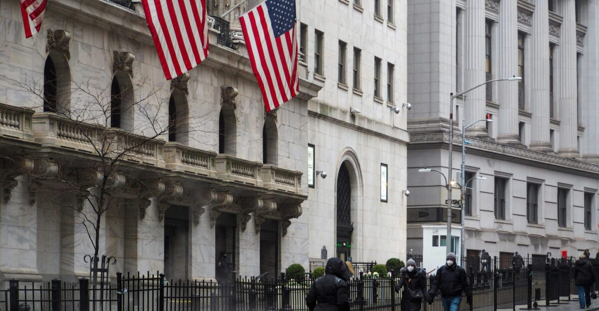 a group of people walking down a street next to tall buildings