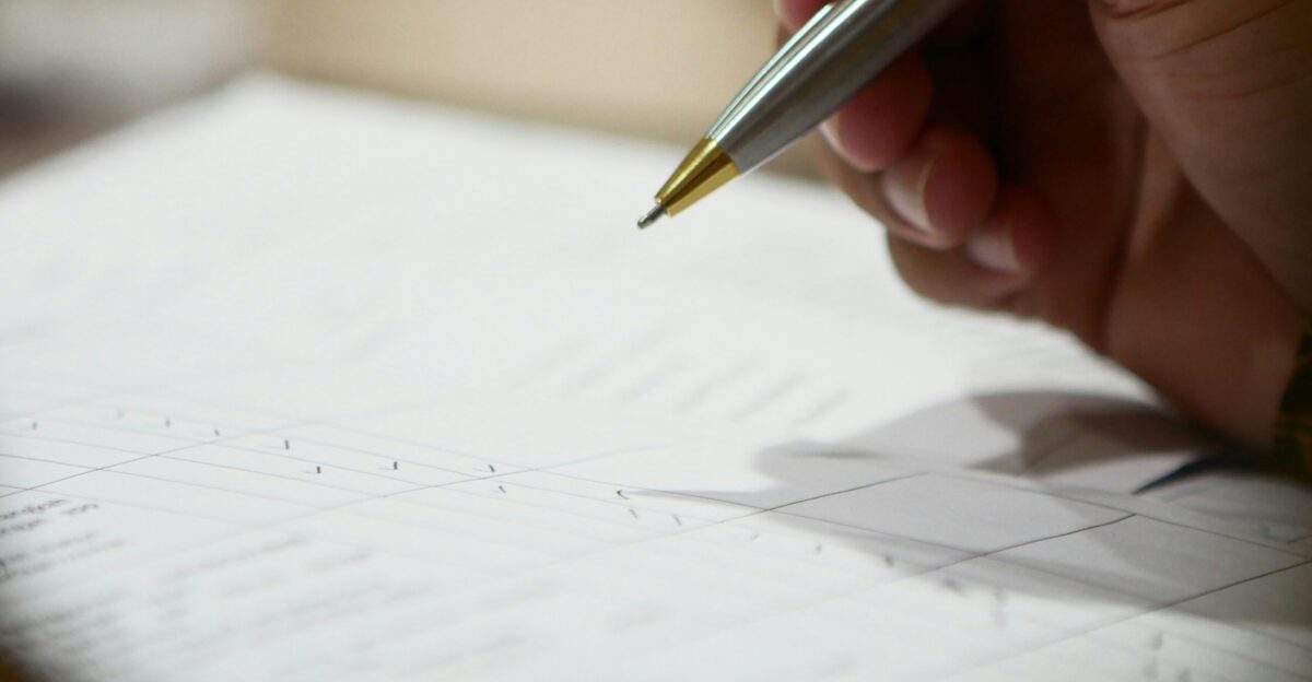 a hand holding a pen