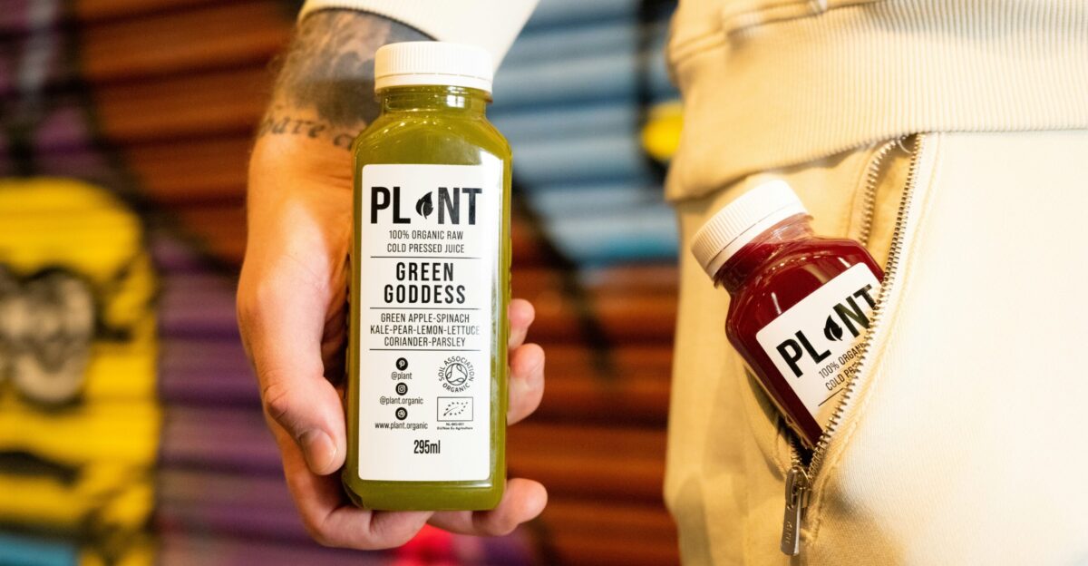 a person holding a bottle of green juice