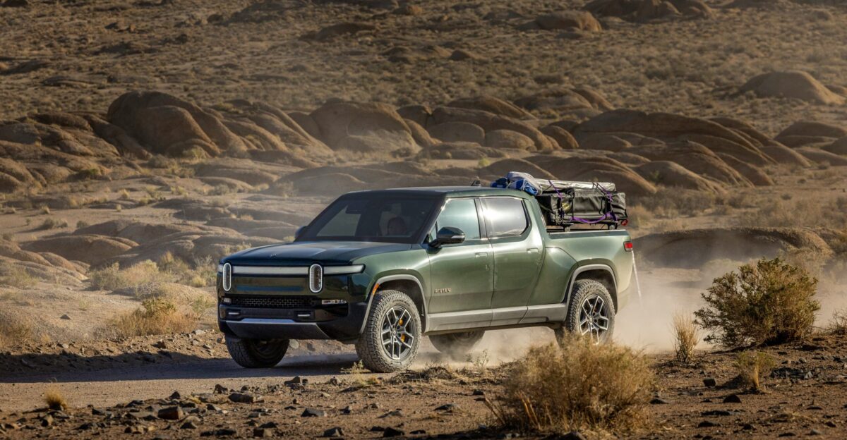 a green truck driving down a dirt road