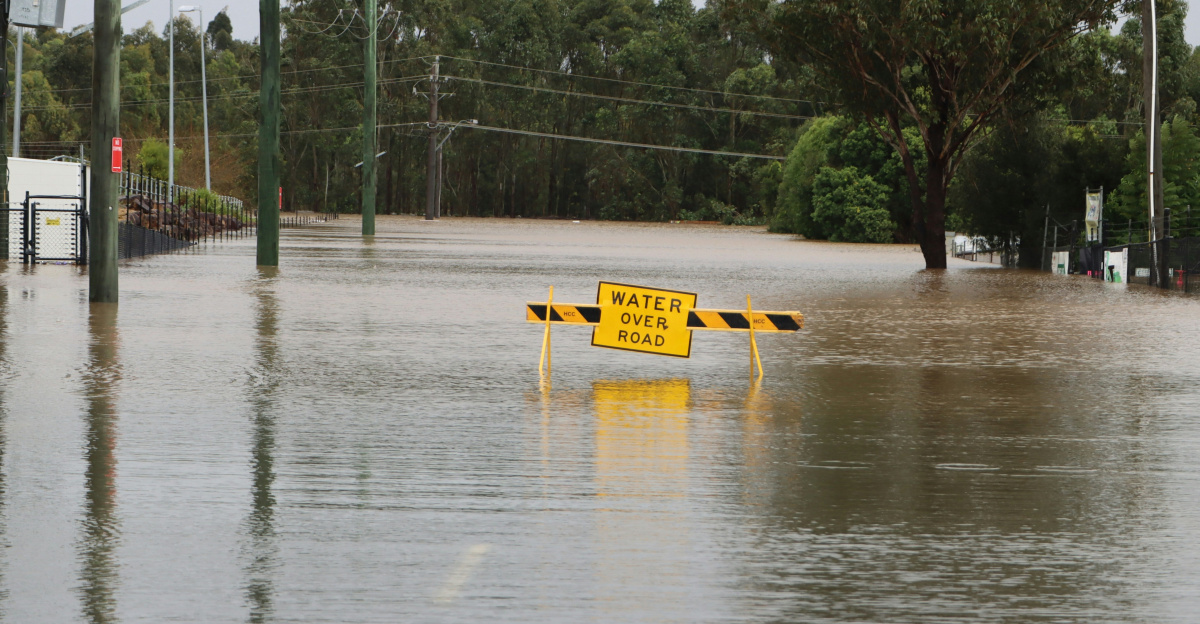 a flooded street with a yellow sign