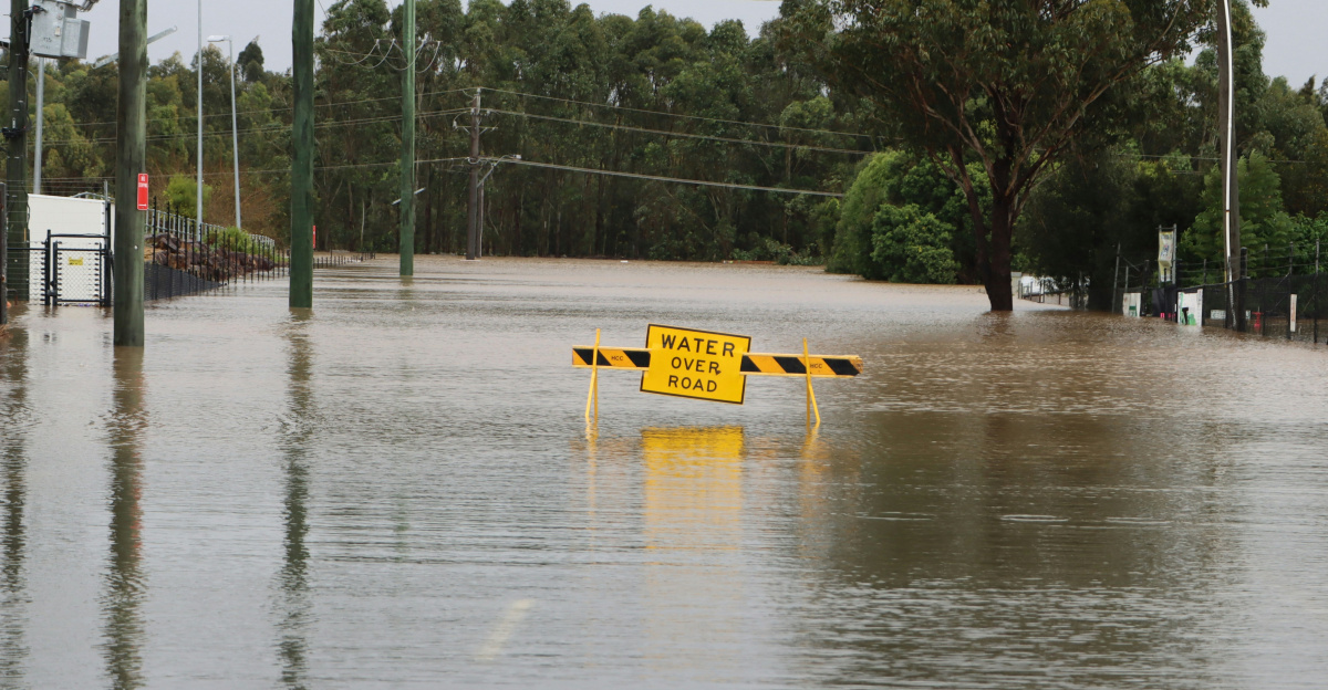 a flooded street with a yellow sign