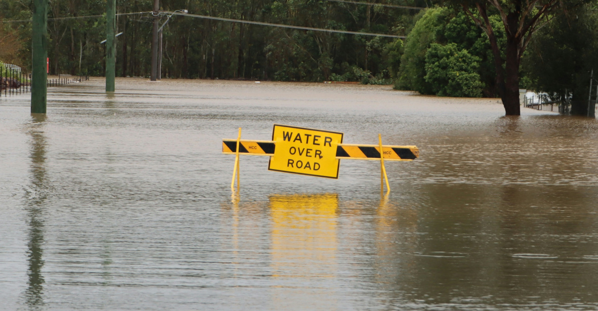 a flooded street with a yellow sign