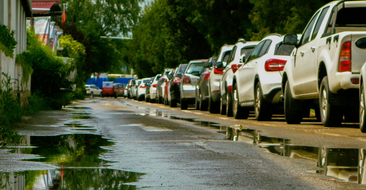 a flooded street with cars parked along it