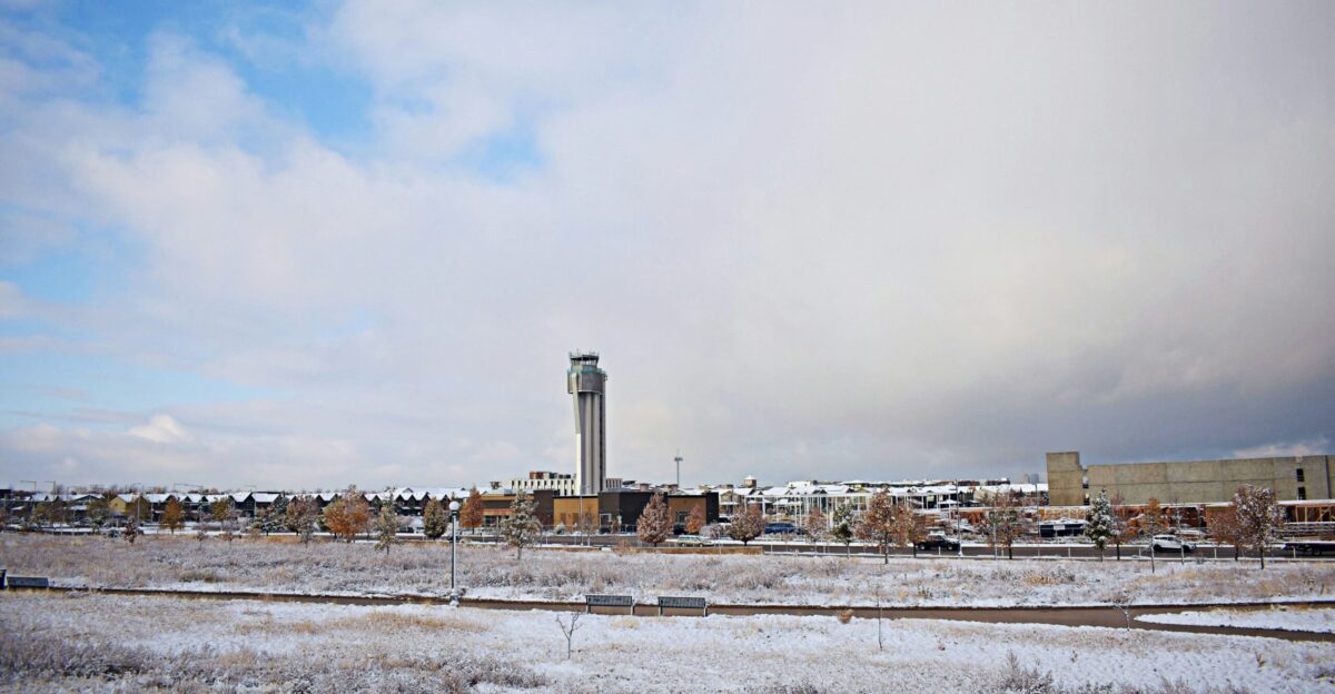 a snowy field with a clock tower in the background