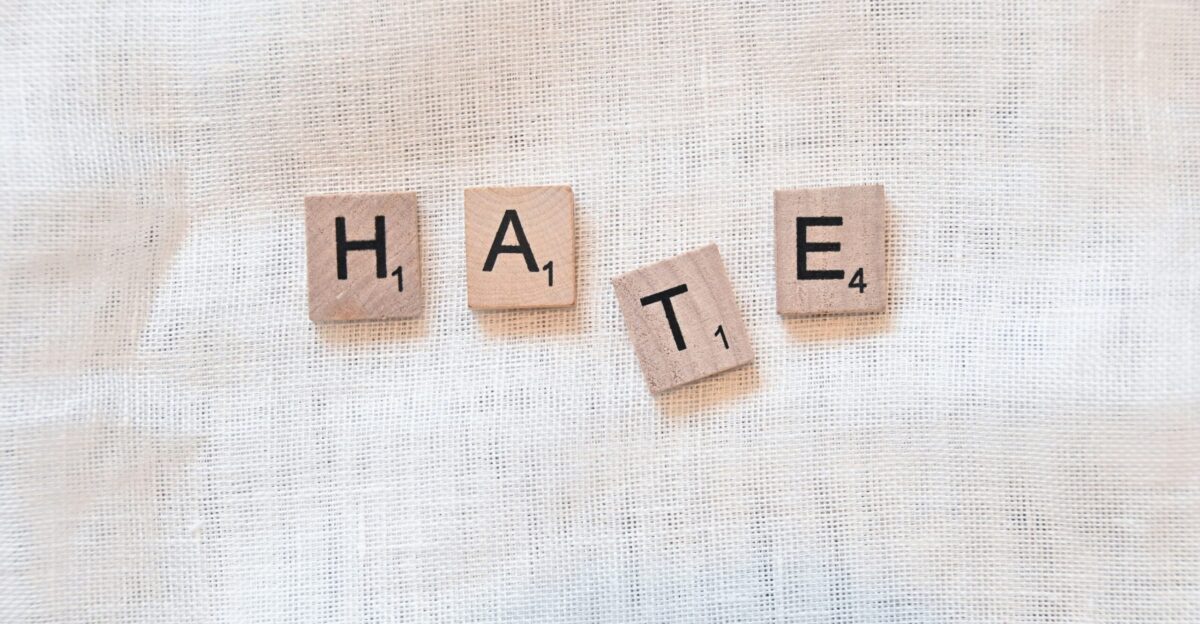 the word hate spelled with scrabbled wood blocks