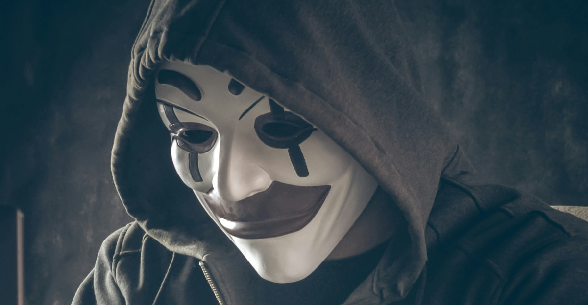 a person wearing a mask using a laptop